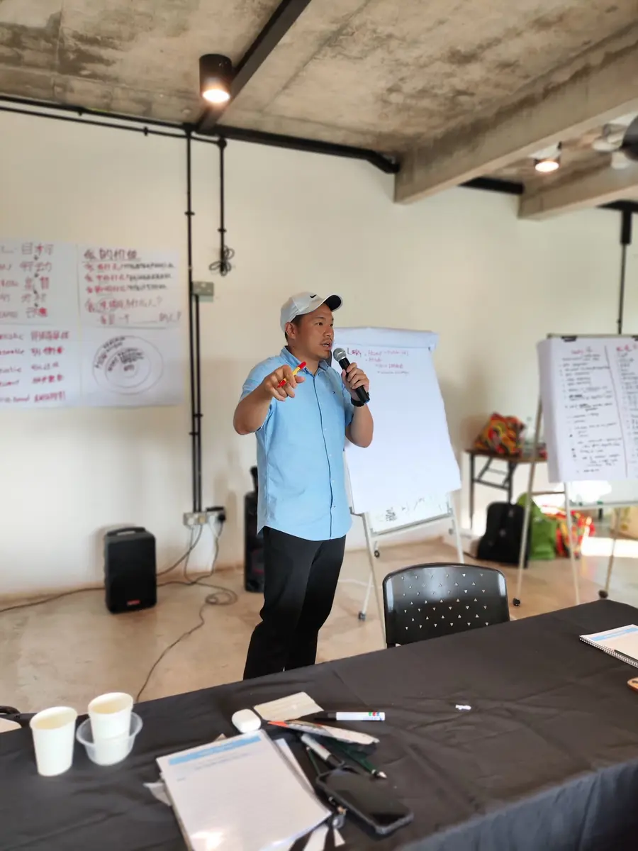 YJ facilitating an indoor NLP Practitioner training session
